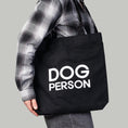Load image into Gallery viewer, Schwarzer Jutebeutel mit weißem „Dog Person“-Print von Karma Hund, frontal fotografiert.