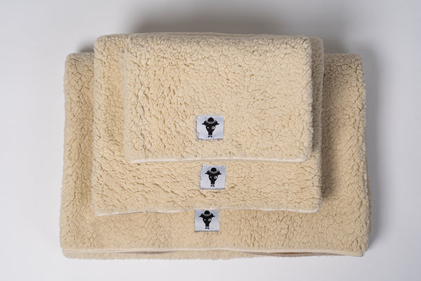 Die doppelseitige Hundedecke zusammengelegt, genutzt als gemütliche Unterlage für kleine und große Hunde.